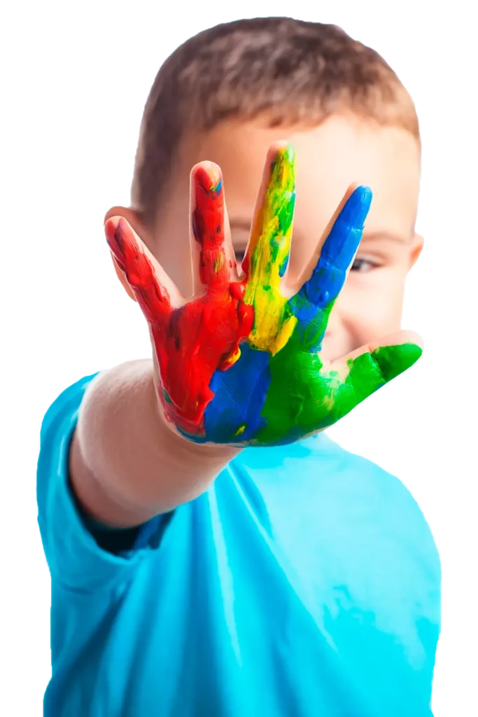 Menino sorrindo com a palma da mão erguida, pintada de vermelho, amarelo, verde e azul